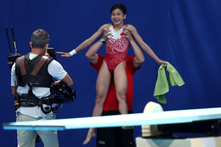 Quan Hongchan is lifted into the air by her coach on winning the gold medal. © Getty Images