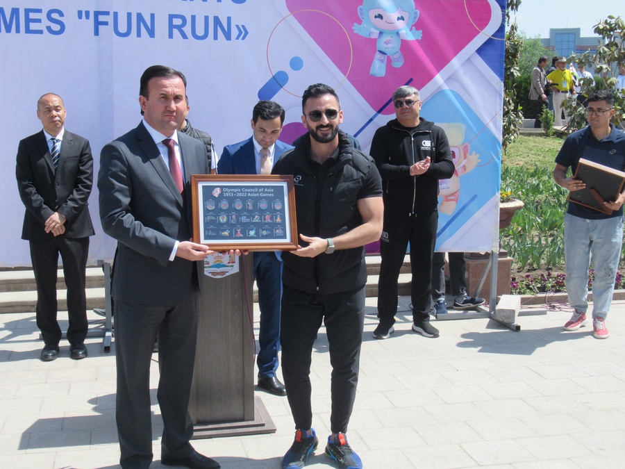 OCA representative Wissam Trkmani presents an Asian Games pin badge souvenir to Sports Minister Rahmonzoda Abdullo. © OCA