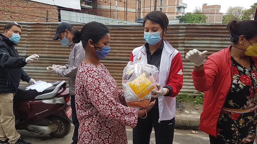 Table tennis player Elina Maharjan distributing food. © The Himalayan Times