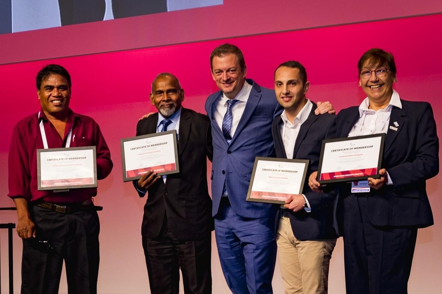 Ibrahim Ismail Ali (2nd from left) stands next to IPC President Andrew Parsons at the 2019 General Assembly in Bonn, Germany. © International Paralympic Committee
