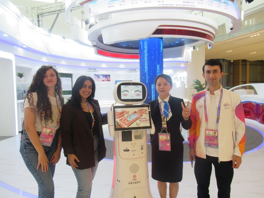 Umed (right) checks out the Main Media Centre and the ICBC outlet with two of his fellow young reporters. (Photo: OCA)