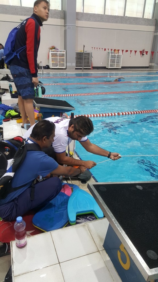 Pakistan coach Abdul Aziz Chaudhry (white t-shirt) and Indian counterpart Girish Basavalingappa fixing the lane marker together.