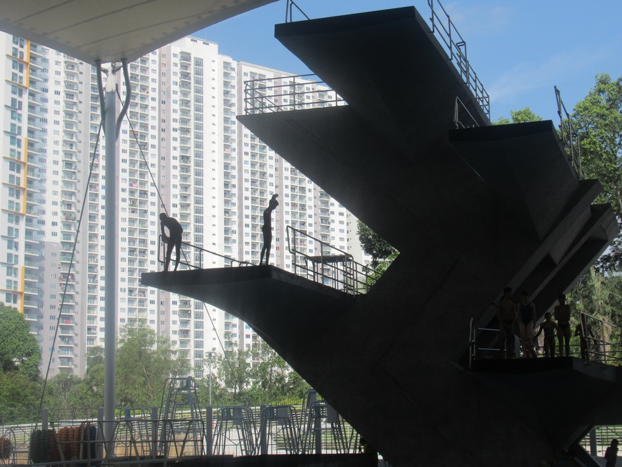 Young divers are silhouetted against the Malaysian skyline at the National Aquatic Centre in Kuala Lumpur. © OCA