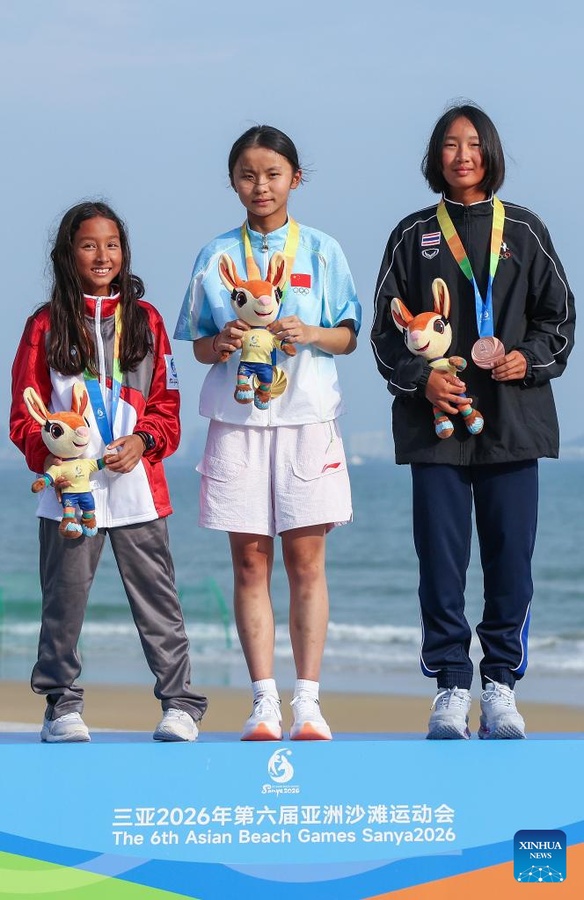 Gold medalist Cheng Wenyu (centre) of China, silver medalist Zahedi Anya Alessia (left) of Singapore and bronze medalist Pariyaporn Chantarawong of Thailand take part in the award ceremony for the Optimist Girls race on April 28, 2026. (Photo: Xinhua/Zhang