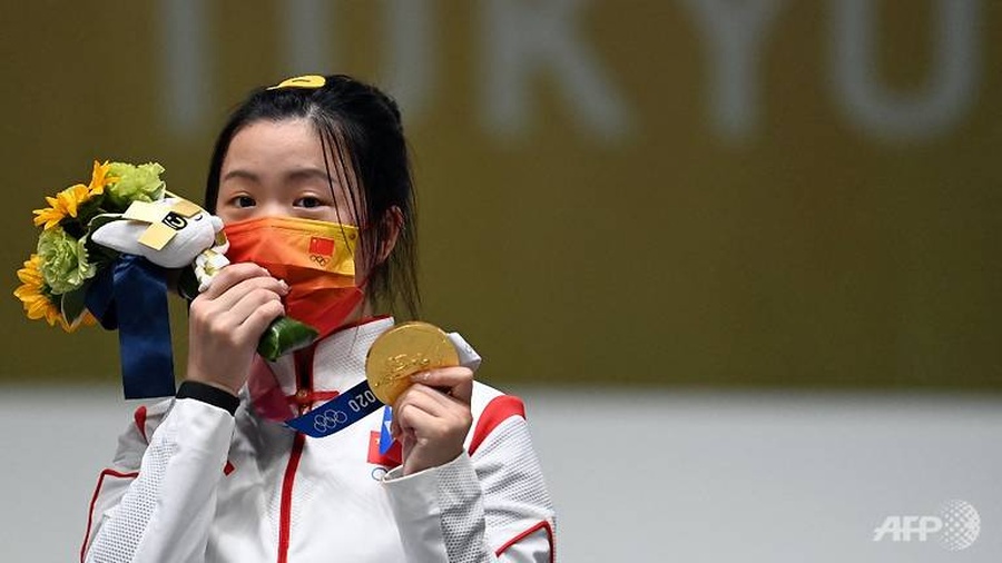 China's Yang Qian celebrates on the podium after winning the women's 10m air rifle final at the Asaka Shooting Range on Saturday, July 24. © AFP/Tauseef Mustafa