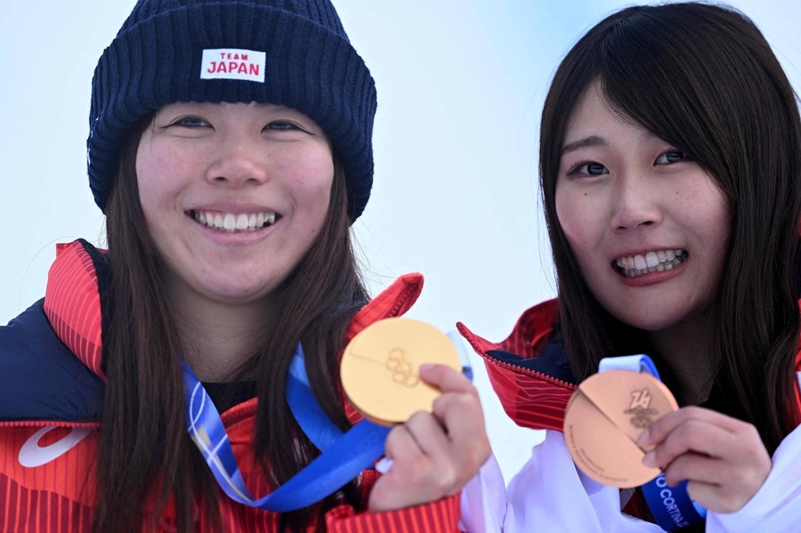 Mari Fukada (left) and Kokomo Murase display their Olympic medals on the podium after the snowboard women's slopestyle final on Wednesday in Livigno, Italy. (Photo: AFP-JIJI/Japan Times)