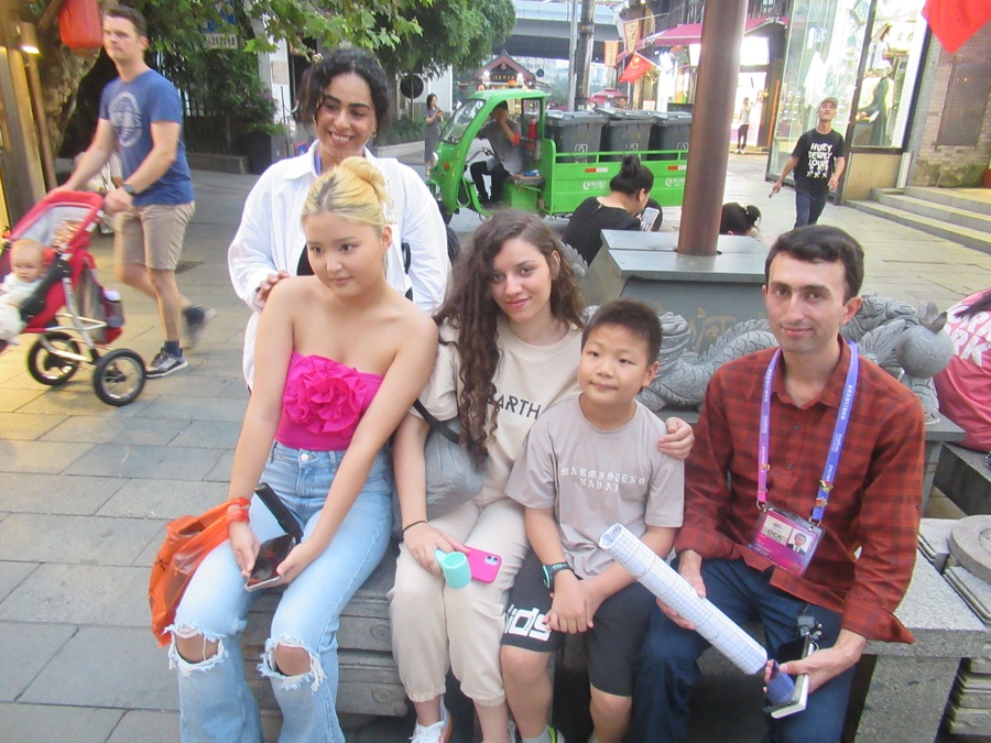 Dana is pictured (centre) with fellow OCA young reporters and a young admirer. (Photo: OCA)