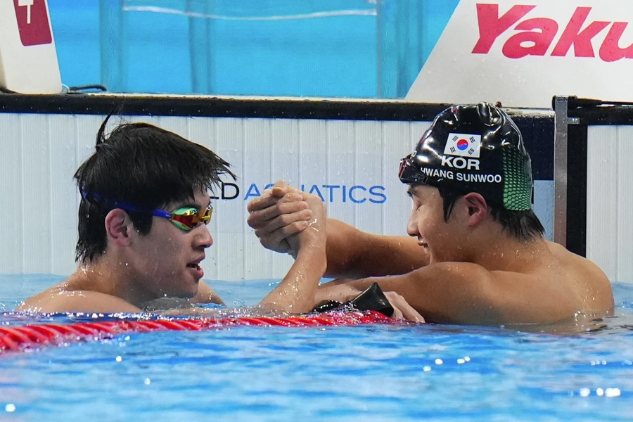 Pan Zhanle is congratulated by Hwang Sun-woo after his victory in the men’s 100m freestyle on Thursday evening in Doha (Photo: Associated Press)