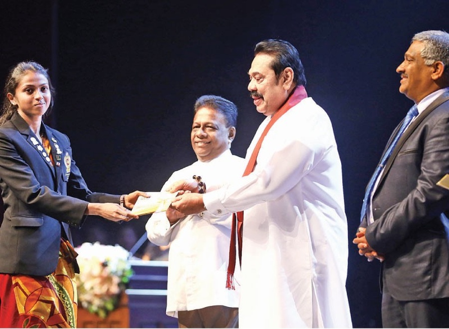 Sri Lanka Prime Minister Mahinda Rajapaksa giving a cash award to athlete Dilshi Kumarasinghe, who won three gold medals in the 400m, 800m and 4x400m relay. © Daily News