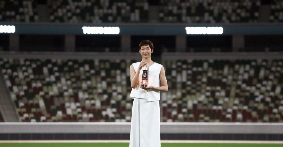 Rikako Ikee poses with a lantern containing the Olympic flame at the Olympic Stadium in Tokyo on July 23.  © Pool via Reuters