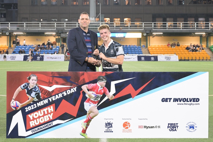 HKRU chairman Chris Brooke present Best & Fairest award to Overseas Lions U19 centre Trent Roussow.