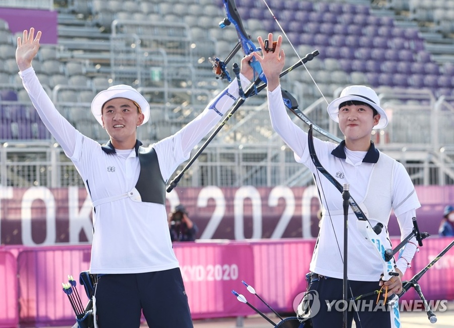 Korean archers Kim Je Deok (left) and An San celebrate their gold medal in the mixed team event on Saturday. © Yonhap