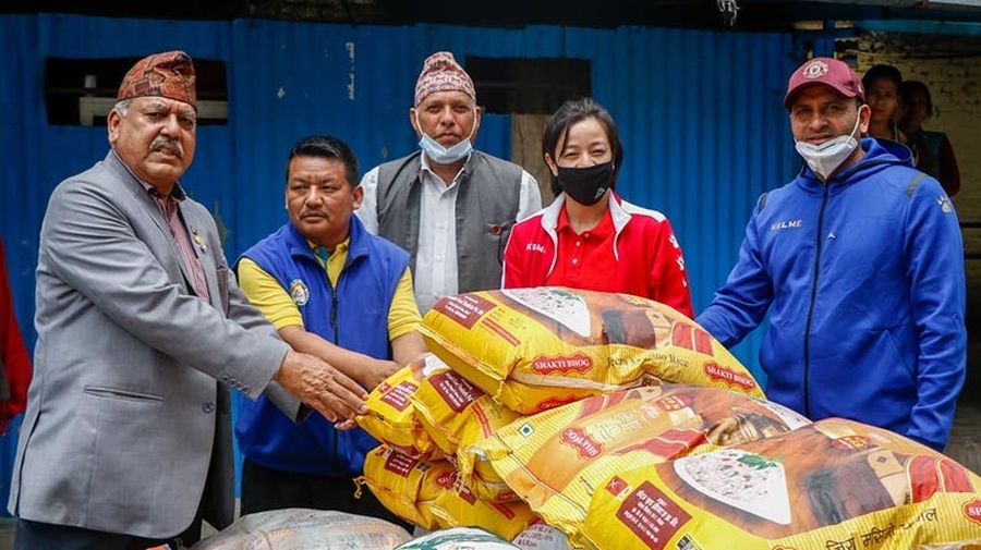Olympian Deepak Bista and his wife Ayasha Shakya handing over relief materials. © The Himalayan Times