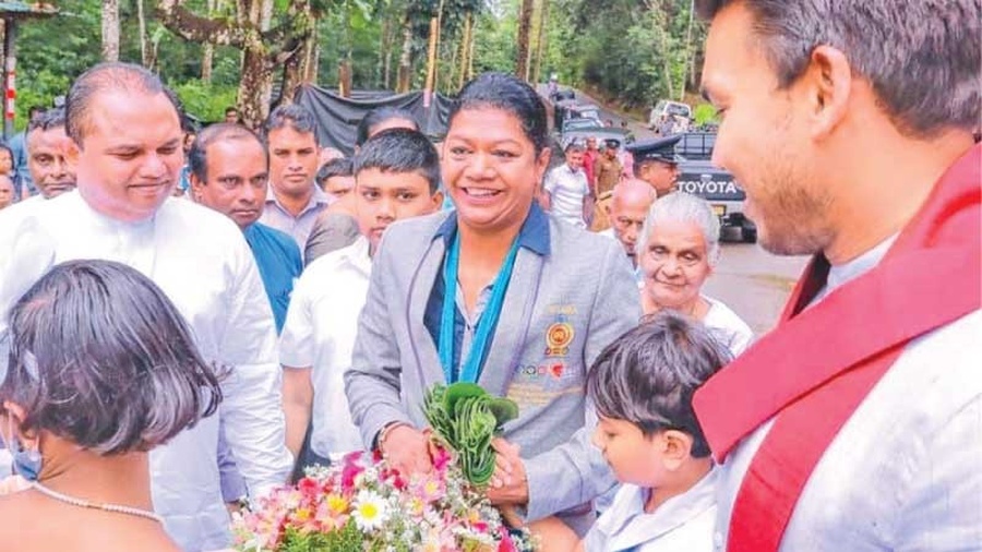 Susanthika Jayasinghe is greeted at her old school by students and Sri Lanka Sports Minister Namal Rajapaksa (extreme right). © Daily News