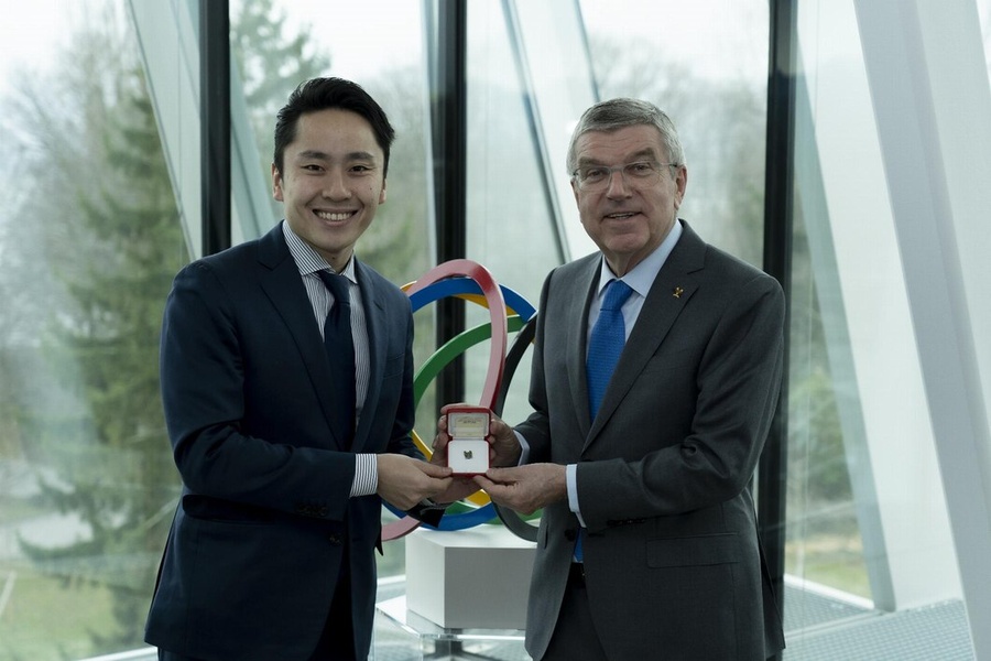 Thomas Bach presents Yuki Ota with his Olympic pin. © IOC/Greg Martin