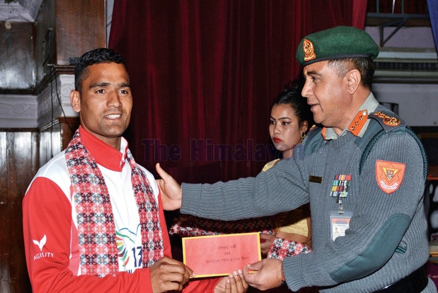 Gopi Chandra Parki, gold medallist in the 5,000m race, receives his cash award from Nepal APF Inspector General Shailendra Khanal at the felicitation ceremony in Kathmandu. © The Himalayan Times