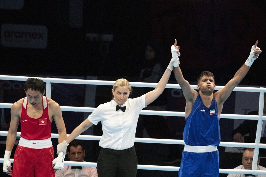 Iran's Daniyal Shahbakhsh raises his arms in triumph after winning the box-off against Rex Tso of Hong Kong, China. © EPA