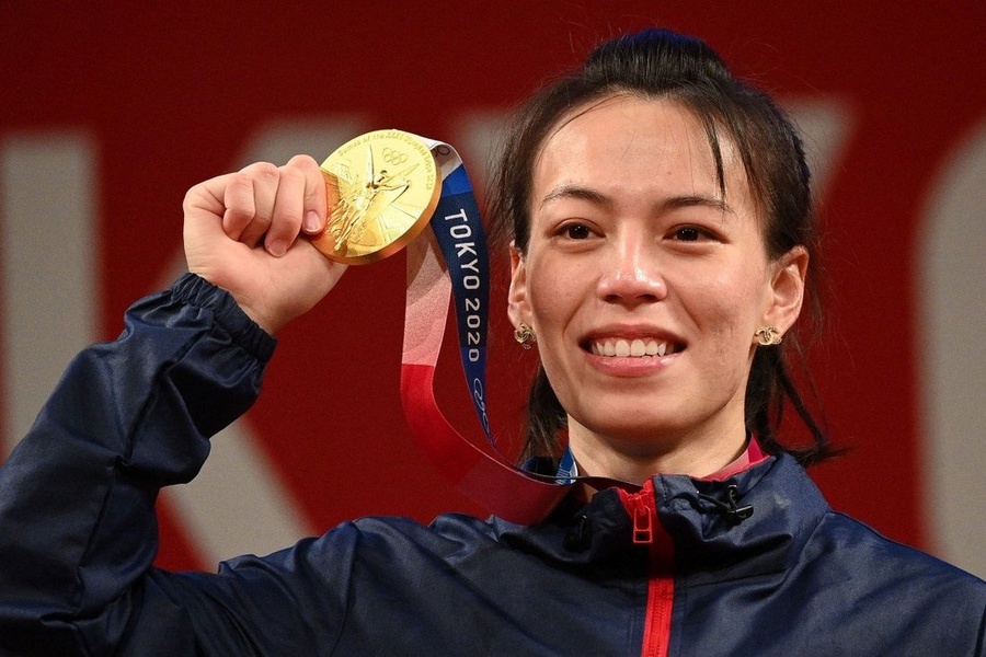 Kuo Hsing-chun shows her gold medal after winning the women’s 59kg weightlifting competition at the Tokyo 2020 Olympics on July 27. © AFP