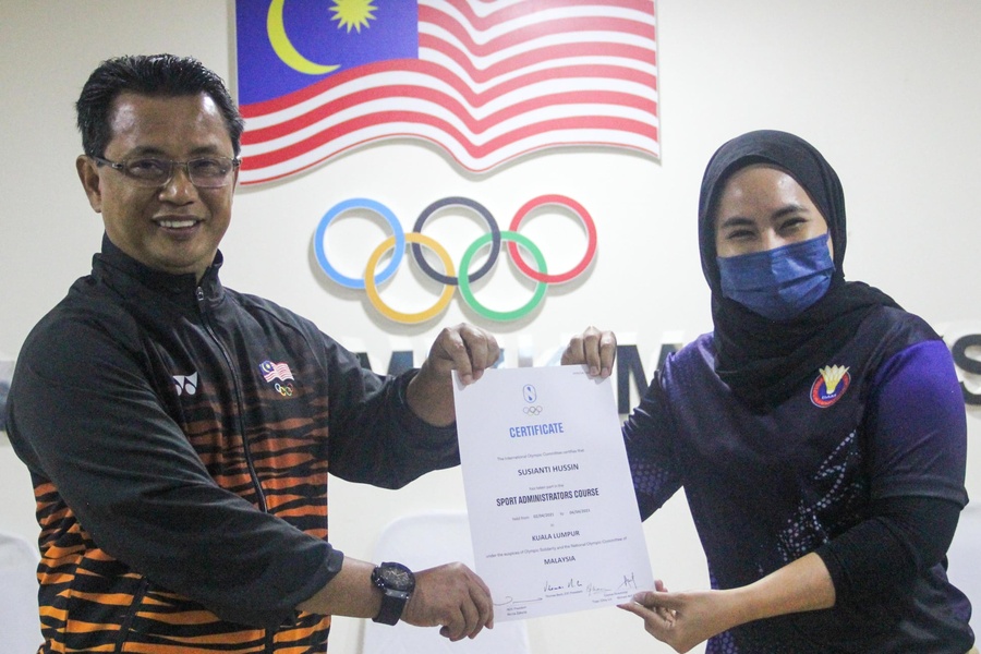Tan Sri Dato' Sri Mohamad Norza Zakaria presents a certificate to Susianti Hussin, Development Executive of Badminton Association of Malaysia. © Olympic Council of Malaysia @Olympic.Council.Malaysia