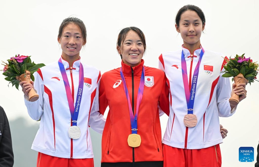 Hangzhou Asian Games women's triathlon individual champion Takahashi Yuko of Japan is flanked by silver medalist Lin Xinyu (left) of China and bronze medalist Yang Yifan of China. © Xinhua/Hu Huhu