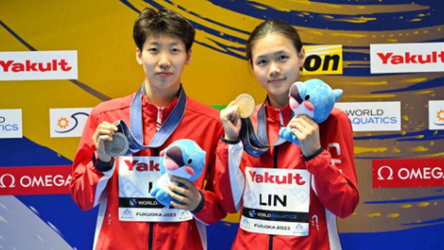 Gold medalist Lin Shan (right) and silver medalist Li Yajie pose for photos after the women's 1m springboard final on Saturday. © Xinhua/Zhang Xiaoyu