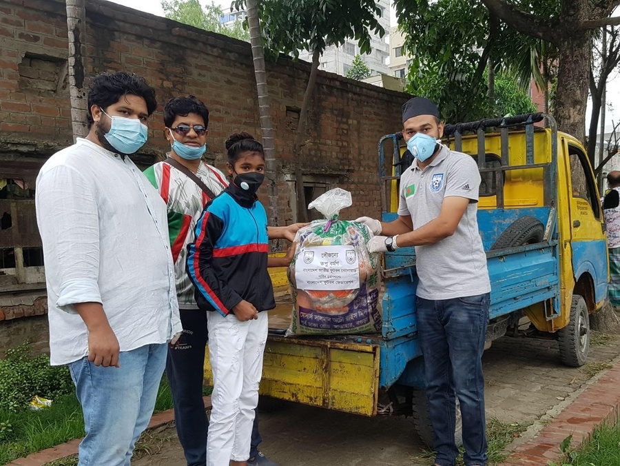 Bangladesh national football player Topu Barman donating food to a female footballer of Narayanganj Promila Football Academy. © Dhaka Tribune