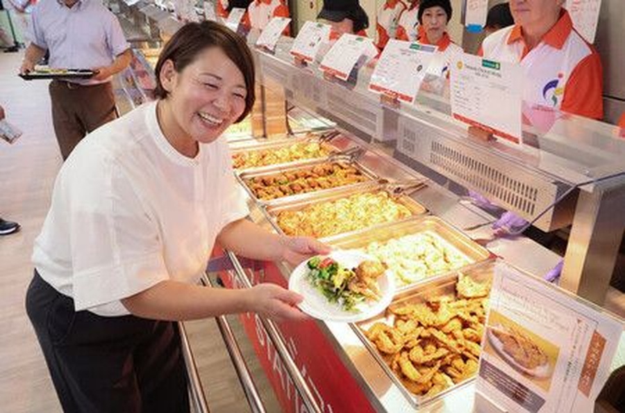 Ayumi Tanimoto, a member of the AINAGOC Athletes’ Committee, tries the food in the dining hall (Photo: Jiji Press)