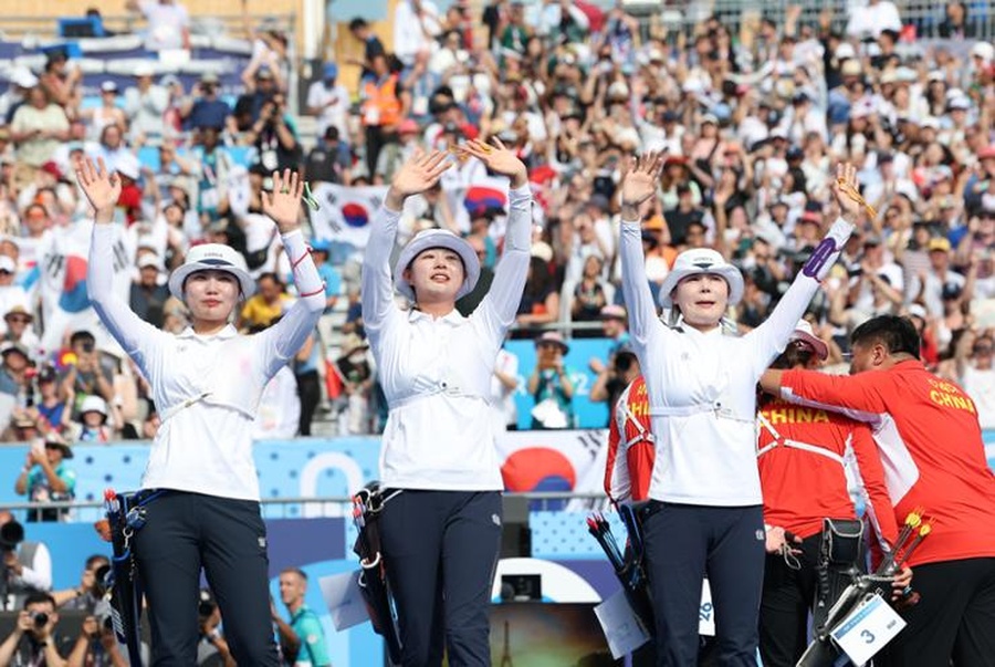 From left, Nam Su-hyeon, Lim Si-hyeon and Jeon Hun-young celebrate after winning the gold medal in the women's archery team event at Invalides in Paris on Sunday, July 28. (Photo: Yonhap)